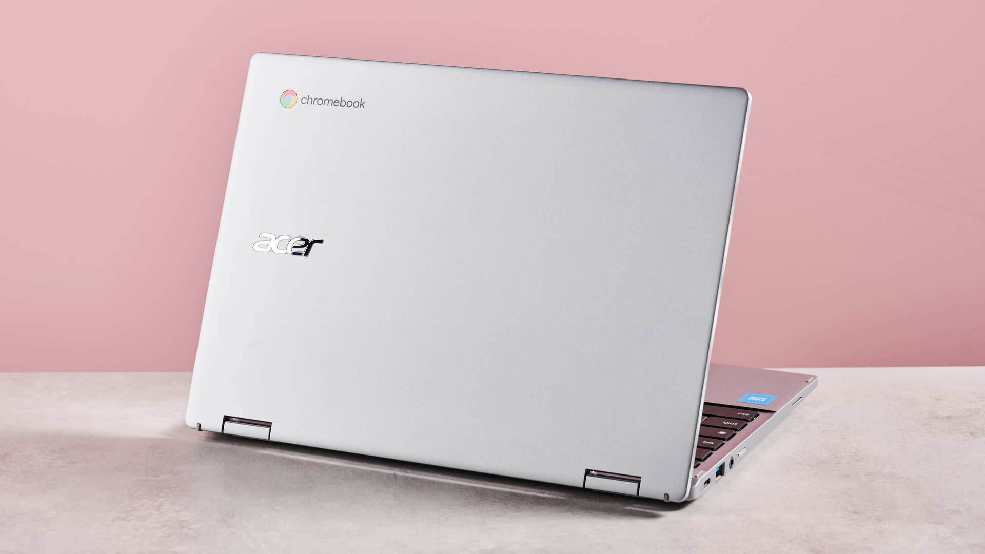 Back of Acer Chromebook Spin 312 open on desk with pink background
