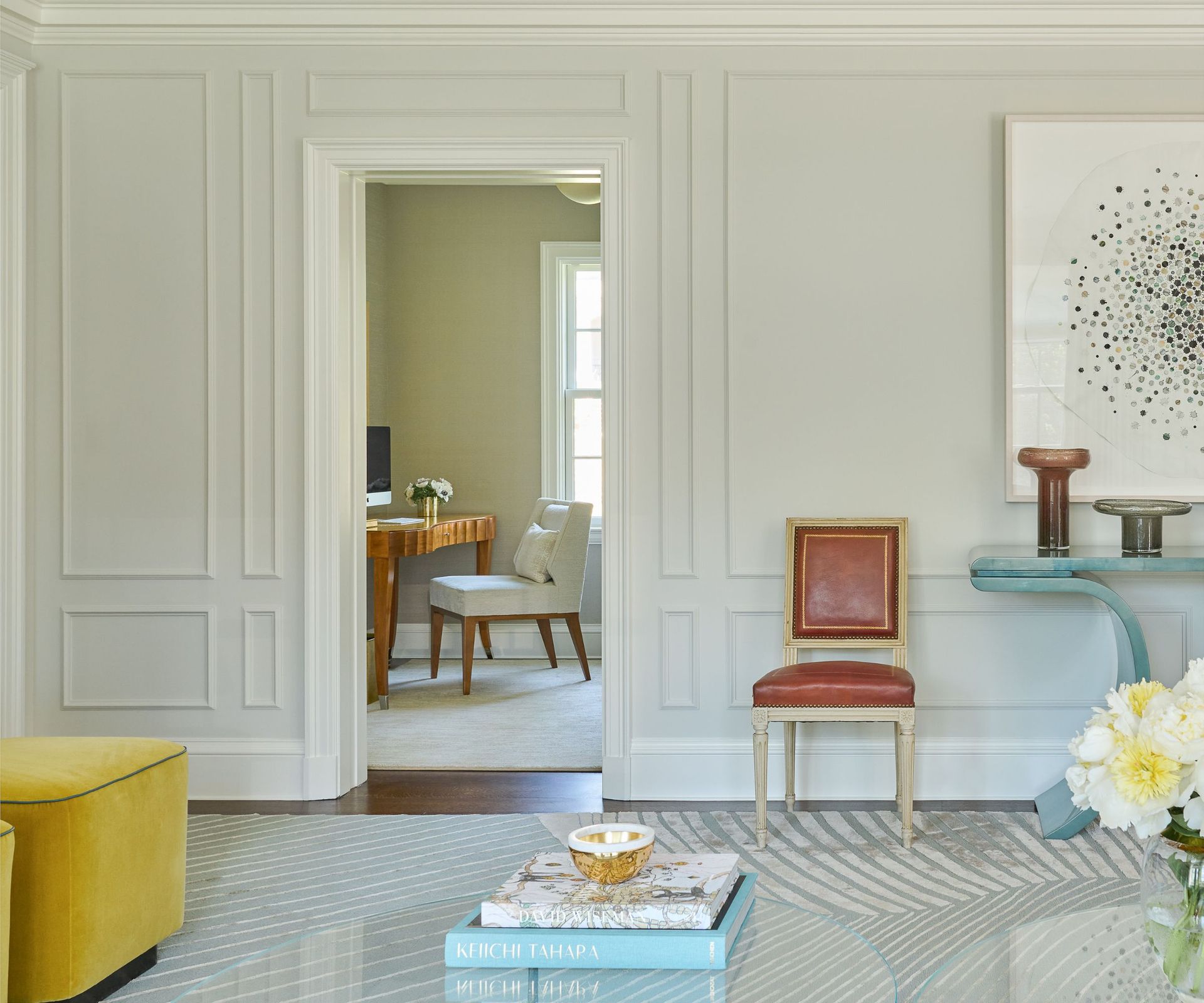 white walls with paneling and red louis XVI chair with modern furniture
