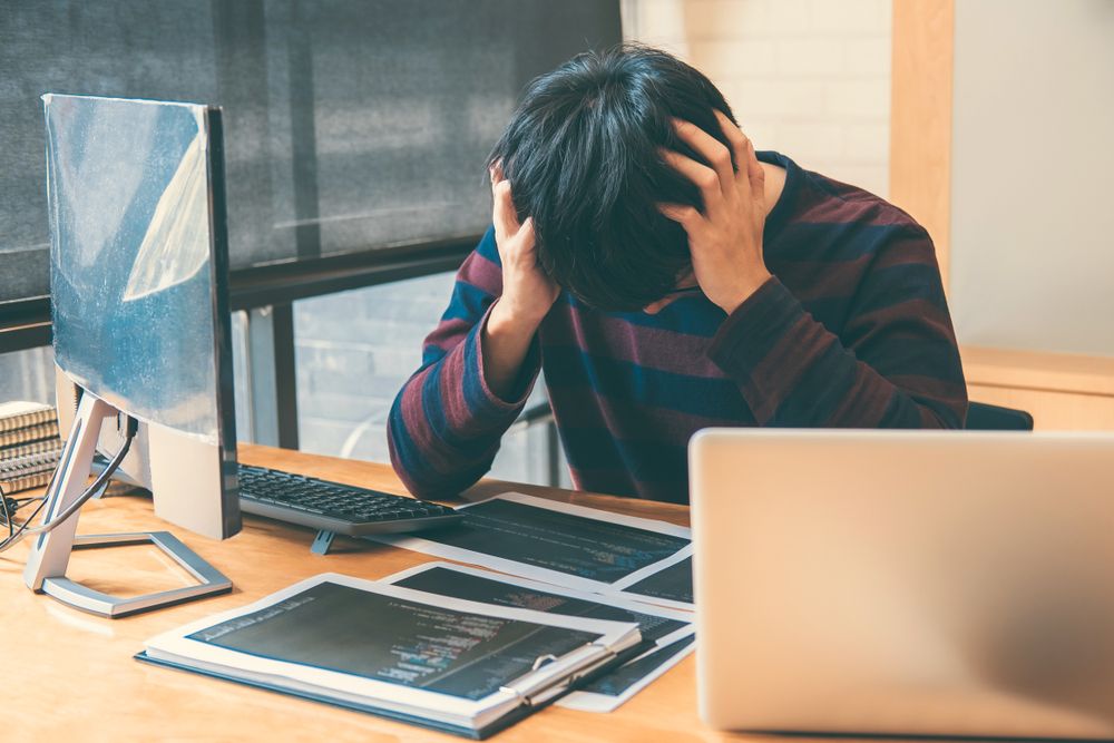 A young professional showing signs of stress at work