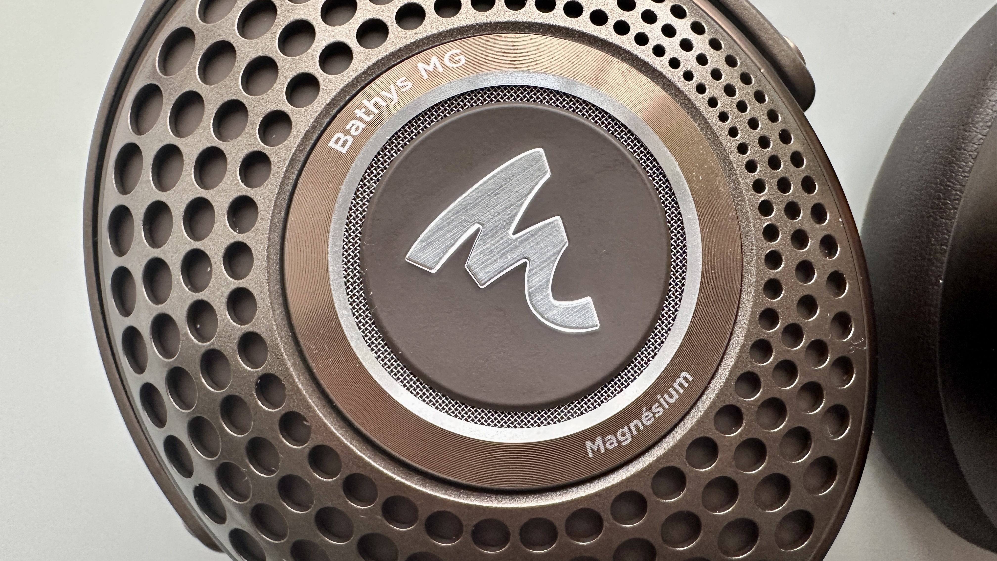 Focal Bathys Mg in bronze, featuring ear cup detail on gray background