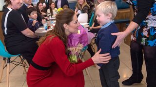 Kate Middleton kneels down to talk to a child during a visit to Mumbles in 2020