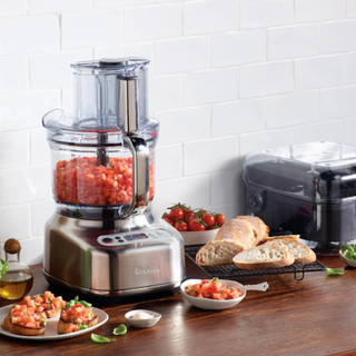 Breville Paradice 16 cup food processor dicing fresh tomatoes, next to a plate of tomato bruschetta