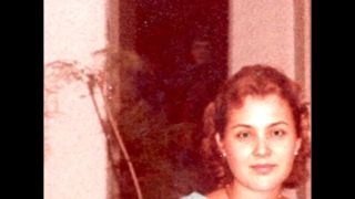 An old photo of a woman with a shadowy figure behind her