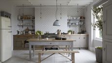 Bright farmhouse kitchen area featuring industrial pendant lighting, weather wood, and Smeg appliances.