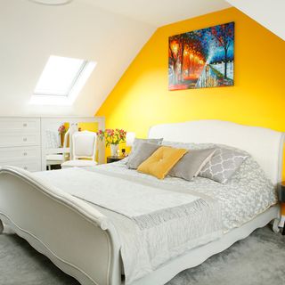 master bedroom with yellow wall and painting on wall