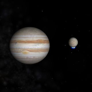 This image shows Jupiter and its icy moon Europa, with the moon's bright ultraviolet light signal from south polar water vapor plumes shown in blue.