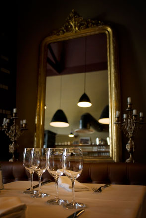 Empty wine glasses with large mirror behind