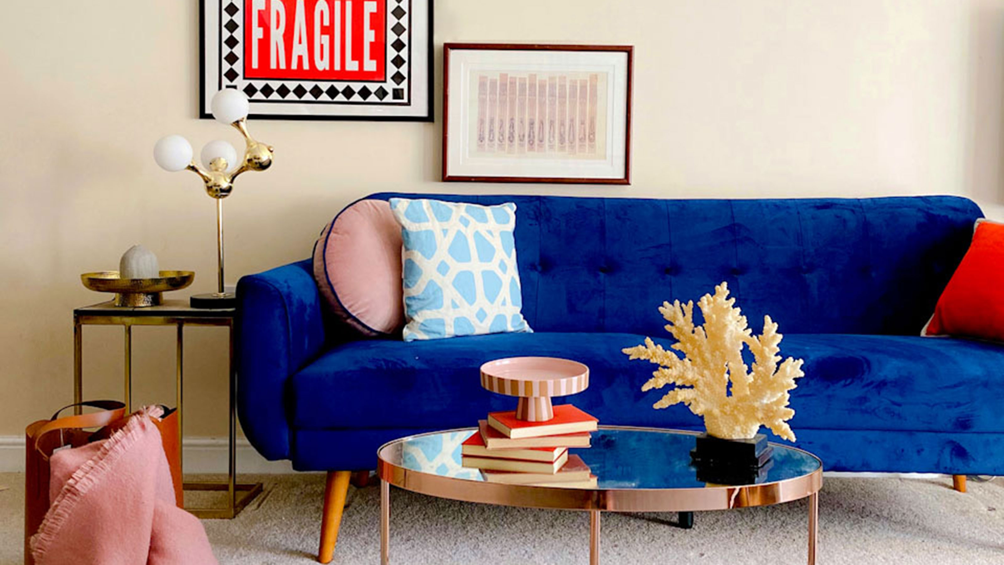Neutral living room with blue sofa, metallic coffee table and art on wall