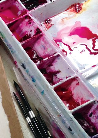 Watercolour trays filled with deep red pigments