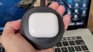 The Apple AirPods 3 being wirelessly charged on an Anker charging pad