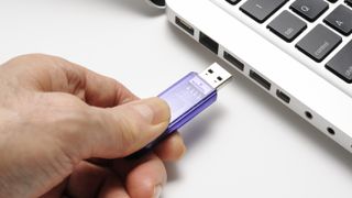 Hand putting one of the best flash drives into a laptop port