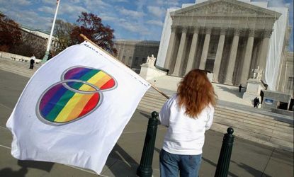 Kat McGuckin of Oaklyn, N.J., holds a gay marriage pride flag in front of the Supreme Court on Nov. 30, 2012. (The building is draped in a photo-realistic sheet while undergoing repairs.)