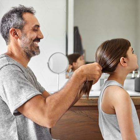 father doing daughter's hair 