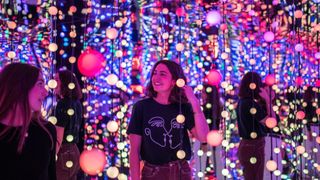 A woman surrounded by strings of lights at Dopamine Land