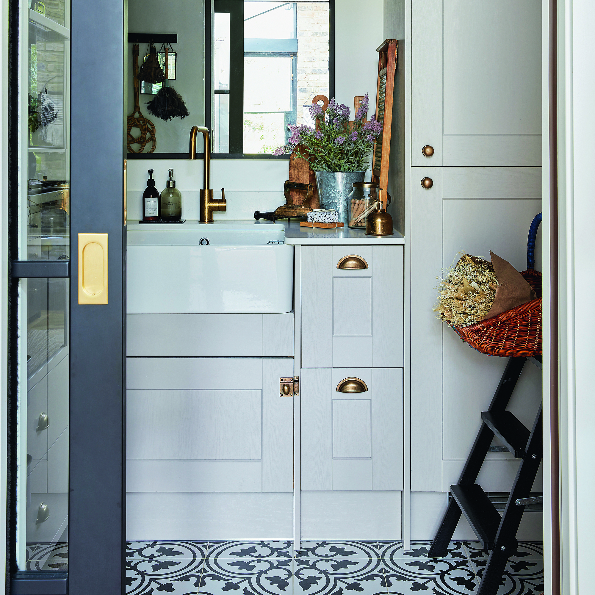 Utility room with glass sliding door, white units and belfast sink