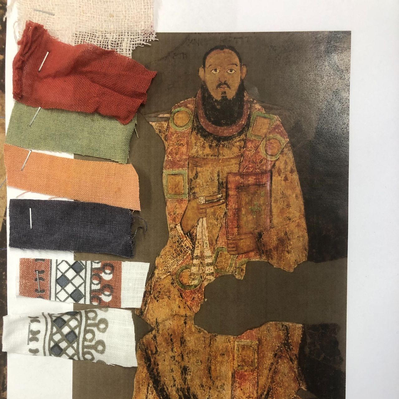 An ancient painting cutout is to the right of a series of small cuts of fabric for comparison.