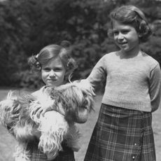 june 1936 queen elizabeth ii as princess elizabeth and her younger sister princess margaret 1930 2002 in the grounds of the royal lodge, windsor princess margaret is holding one of their pet dogs, a cairngorm terrier called chu chu photo by lisa sheridanstudio lisagetty images
