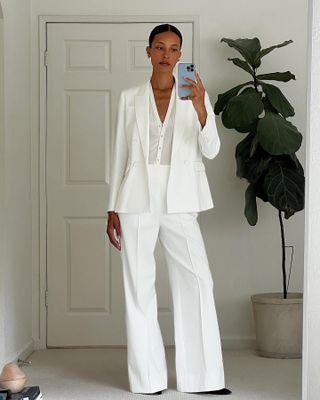 @tylynnnguyen wearing a white suit with a matching sheer henley shirt.