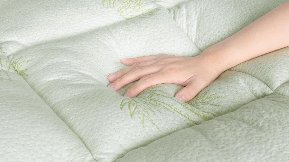 A hand feels the temperature regulation of the SPRINGSPIRIT Dual Layer Mattress Topper.