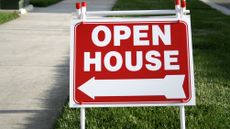 Red open house sign on grass verge