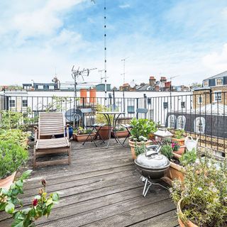 roof terrace with plants table and chairs