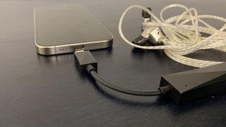 Astell & Kern's HC3 DAC, with an iPhone 15 and Campfire Audio Solaris Stella Horizon wired earbuds, on navy background