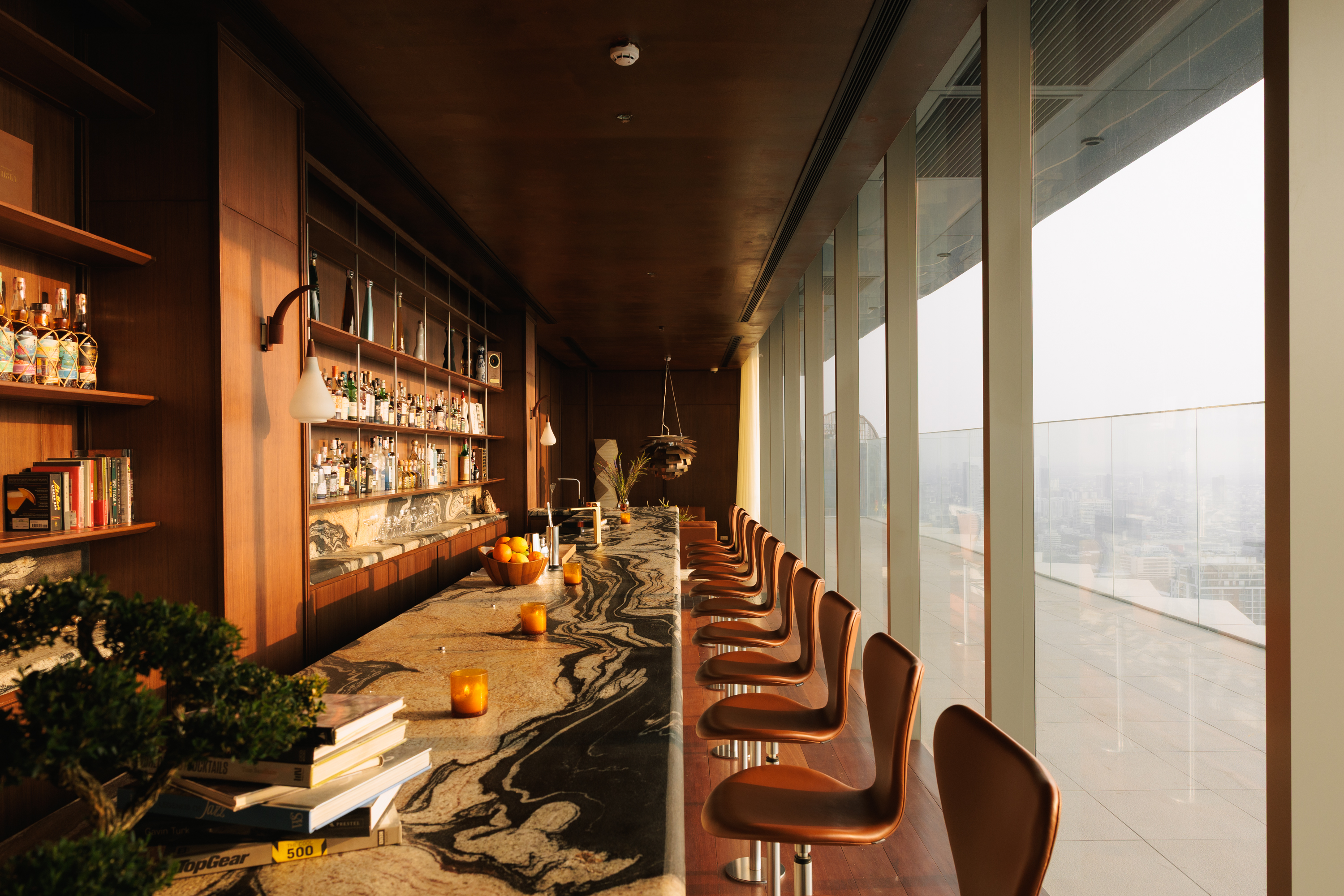 rooftop bar interior with warm wood and Fritz Hansen furniture