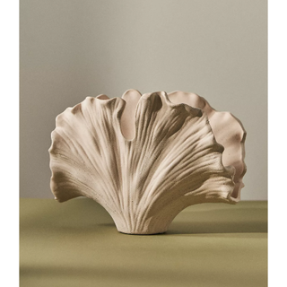 beige ceramic vase in the shape of a curved ginkgo leaf