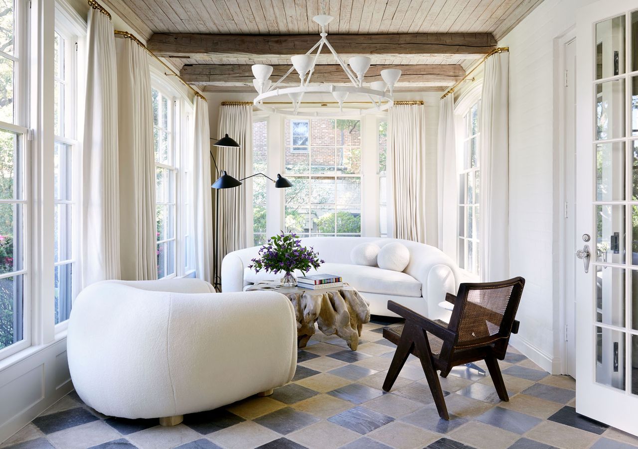 White curved sofa and armchair, tree trunk table and tiled floor