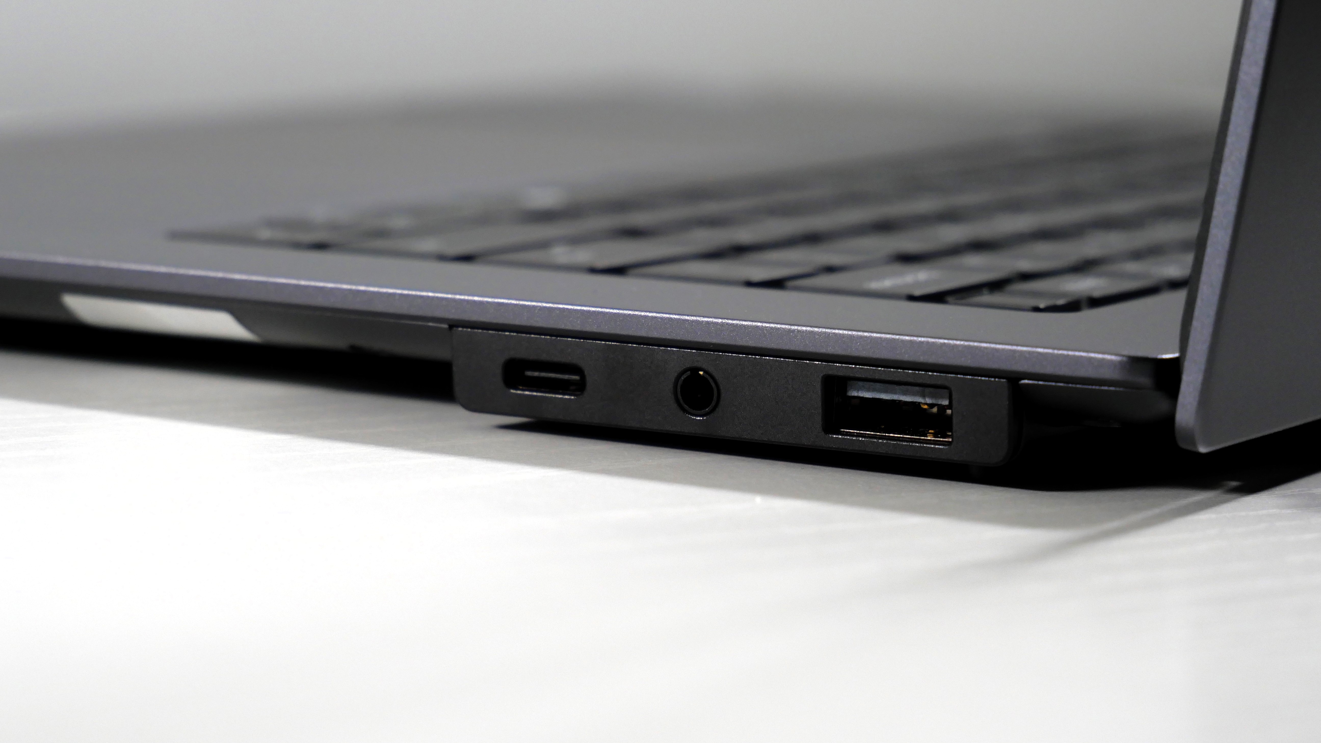 Lenovo ThinkPad X9-15 Gen 1 Aura Edition open on a white desk, highlighting the ports on the right.