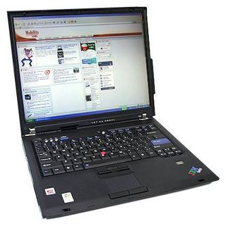 The Lenovo ThinkPad T60 in action. The fingerprint reader is just above the IBM logo. The bump on the right side of the display section is the wireless Wide Area Network antenna. Note that the T60 has both a touchpad and joystick for mousing around.