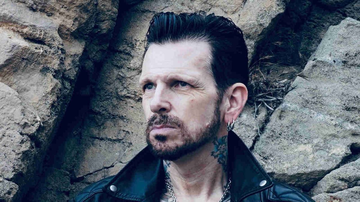 Ricky Warwick posing for a photograph on rocks