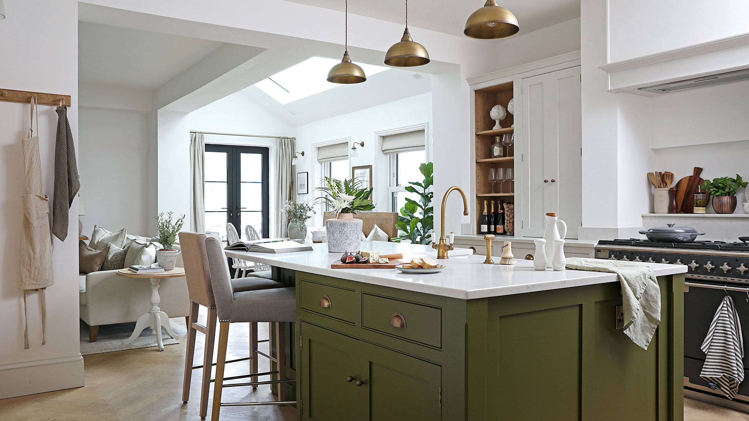 Green kitchen with white walls and gold pendant lights