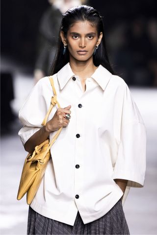 Model at Bottega Veneta wearing the slicked-back hair, a key Spring/Summer 2025 fashion month beauty look