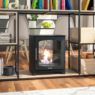 black double sided bioethanol fireplace placed on bottom of open room divider unit