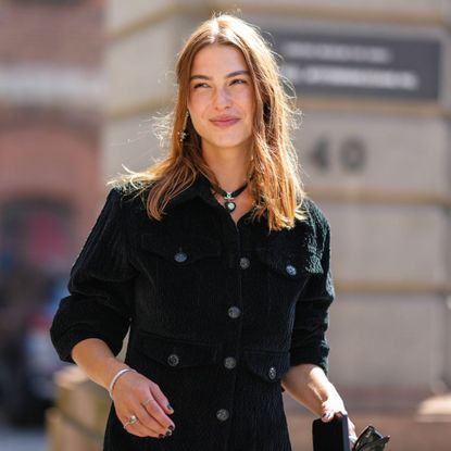 red haired woman in black jacket with glowy skin