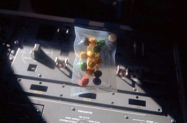 A package of candy-coated chocolate peanuts, or Peanut M&amp;M&#039;s, floats on the flight deck of space shuttle Discovery in 1984.