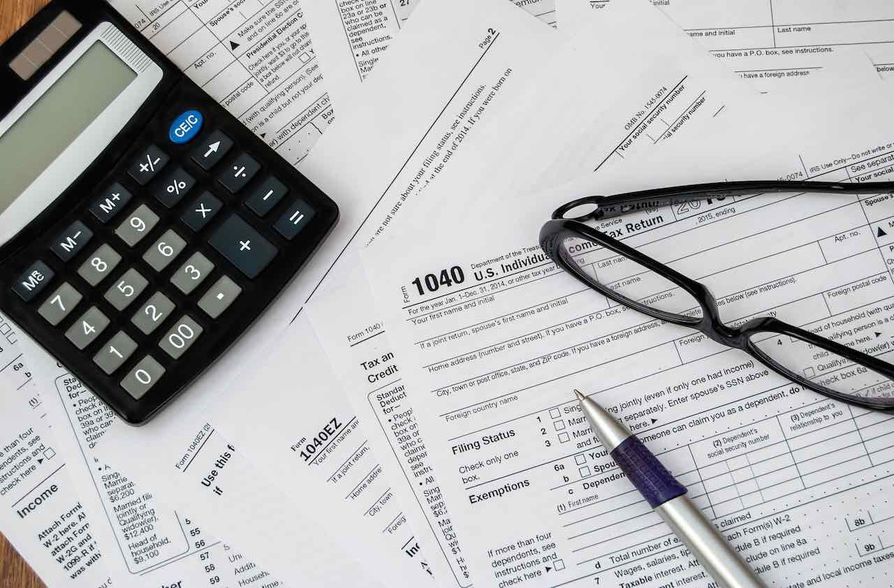 pen, glasses and calculator on the tax form