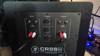 The rear of the Mackie CR8SBT subwoofer with input and output cables attached