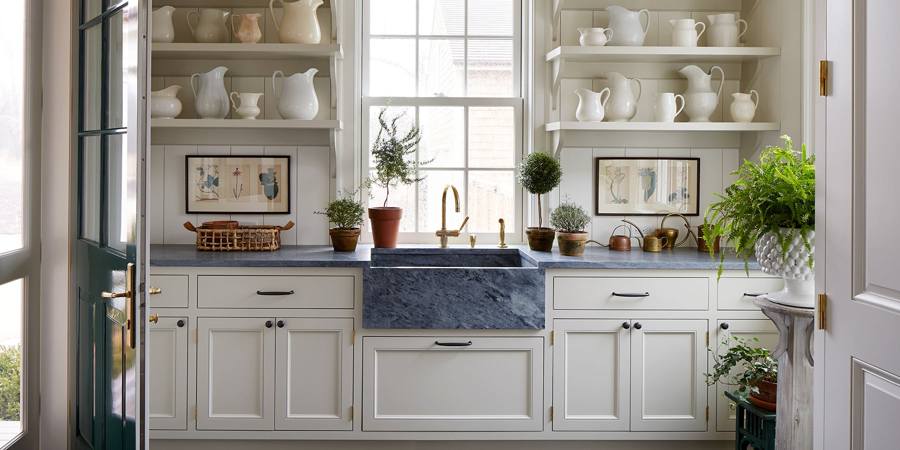 Flower room with white kitchen cupboards and a blue-grey marble countertop 