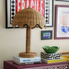 Woven lamp on coffee table books in front of gallery wall