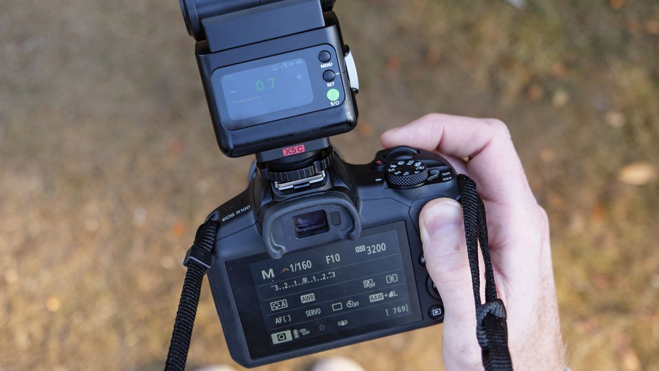 Godox iT32 camera flash attached to a Canon camera, held by photographer and TechRadar's Cameras Editor Tim Coleman