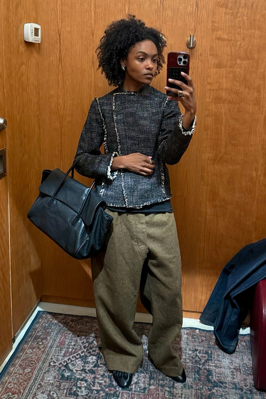 A woman wearing a denim jacket and green pants.
