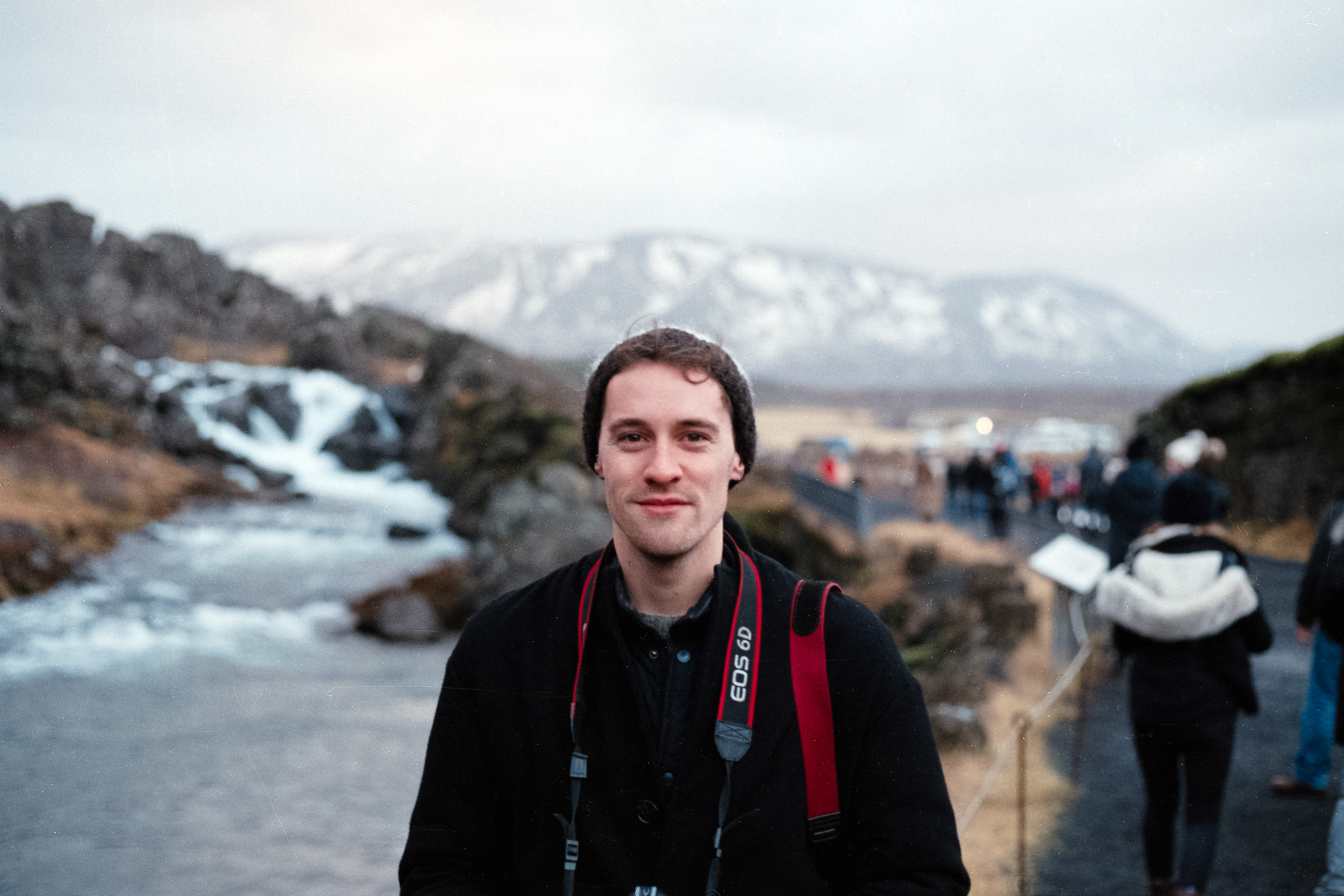 Person standing posing for a photo in front of a small waterfall in Iceland