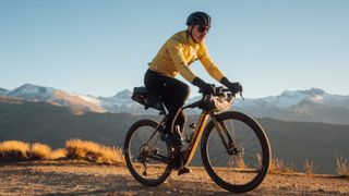 a man riding the Orbea Denna on gravel in a mountainous location
