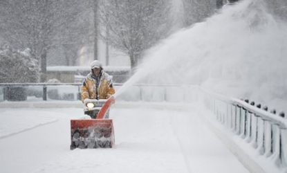 A man clears snow from Chicago's Millennium Park skating rink on March 5.