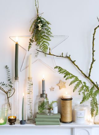 fireplace decorated with natural Christmas decorations including brances, leaves and twine on a white backdrop