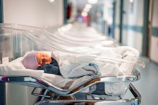 A newborn baby in a hospital bed.