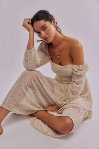 a model wears an off-the-shoulder beige maxi dress