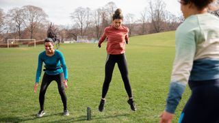 Women doing burpees in a park